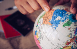 close-up pointers at the globe, tourists are planning to find at close-up pointers at the globe, tourists are planning to find attractions - Conception Travel